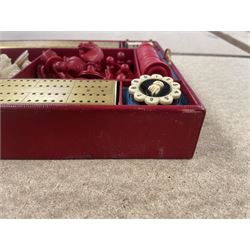 19th century walnut and brass bound games compendium box, painted to enhance the grain, of rectangular form, the hinged opening cover with rounded sides, central brass cartouche with engraved lion crest, and brass riveted straps, opening to reveal a red leather and blue silk lined compartmented interior, with fold-down games board, and lift-out tray containing playing cards, ebony turned dice towers, white and red stained bone draughts, and chess pieces, ivory dice, and ivory and ebony whist markers, and brass bezique board, cribbage board and markers, H15cm W32cm D24cm
This lot has been registered for sale under Section 10 of the APHA Ivory Act
