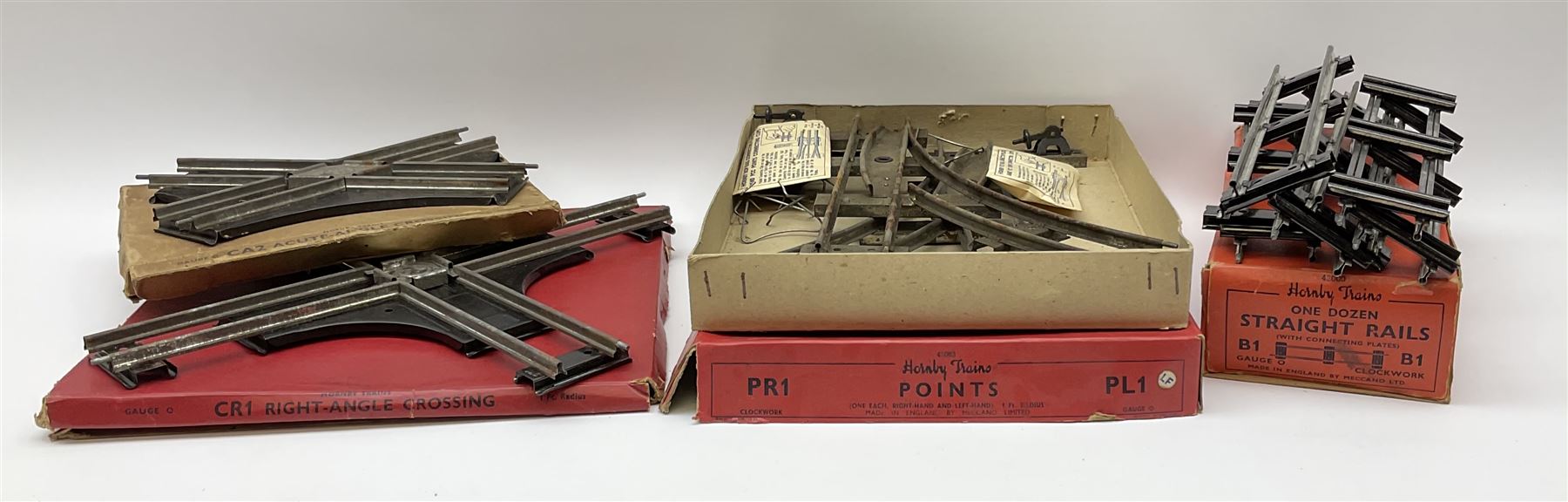 Hornby '0' gauge - layout accessories comprising PR1/PL1 Points, CR1 Right Angle Crossing and CA2 Acute Angle Crossing, all boxed; tin-plate signal box; tin-plate level crossing; textured wooden tunnel, possibly pre-WW2; and quantity of track, some boxed; together with '00' gauge tin-plate station