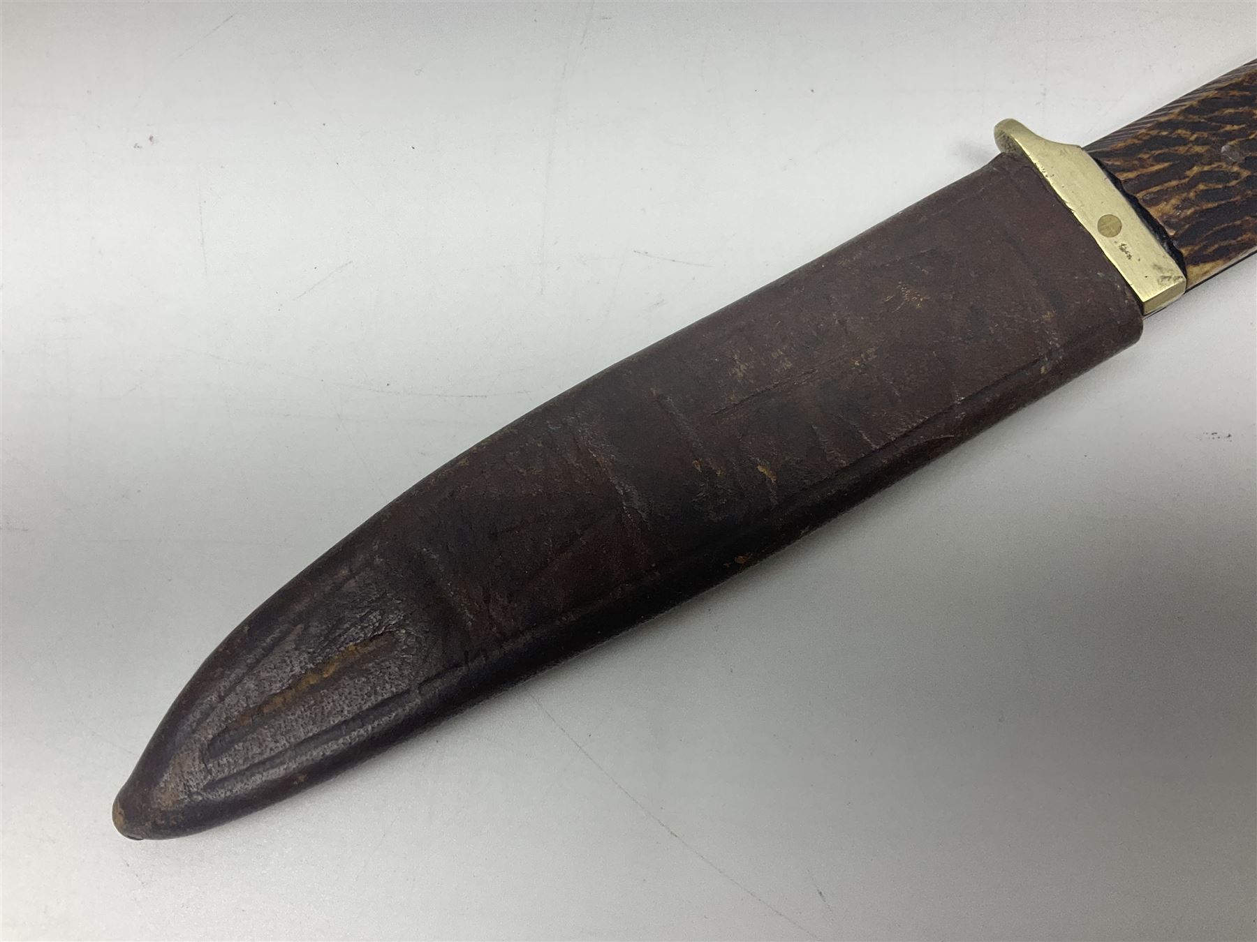 WW2 fighting knife, the 13cm blade by Priestman of Sheffield marked with scout and camp fire motif; two piece antler grip; in leather sheath crudely marked R.T. with a broad arrow L23cm overall Auctioneers Note: By family descent this knife was reputedly presented to Richard Towse during WW2 for guarding a group of POWs.