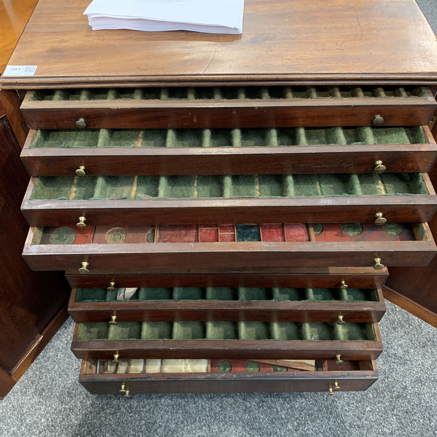 Regency ebony strung mahogany medal or coin collectors cabinet, with reeded top, two panel doors enclosing eleven drawers, shaped out splayed bracket feet
