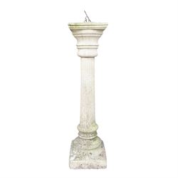 Weathered cast stone sundial on fluted pedestal