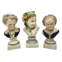 19th century pair of hand painted ceramic busts of children, together with a third similar example of a putti with a crown of ivy, tallest H23cm 