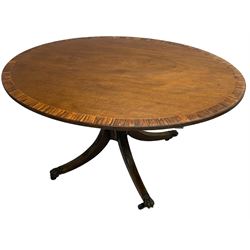 George III mahogany breakfast table, the oval top with a kingwood band and boxwood stringing, raised on a turned vasiform pedestal terminating in a fluted sabre tripod base with hairy paw feet and castors