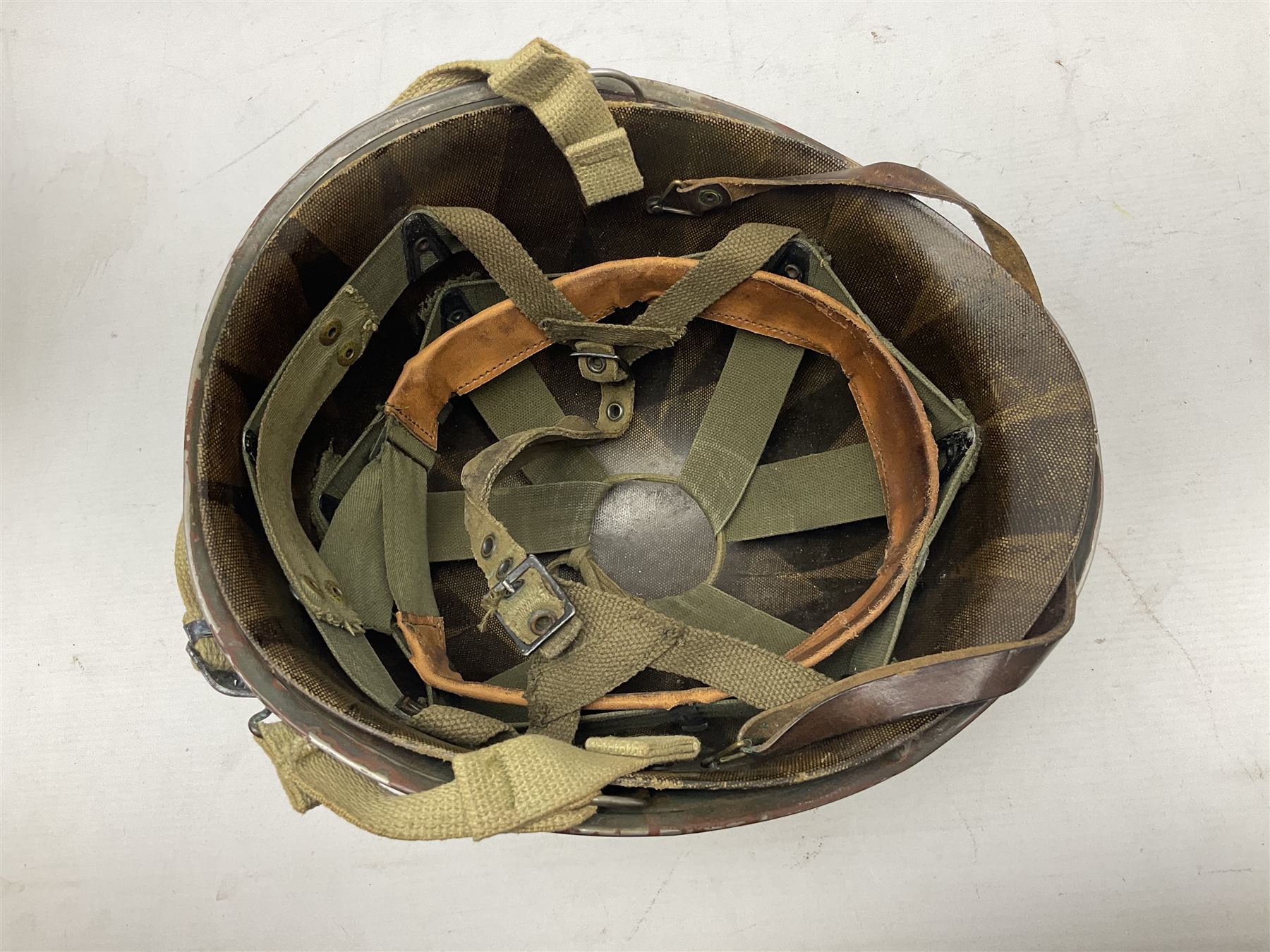 American first type paratrooper helmet with post-WW2 strap and D-rings and later 1944 liner bearing Firestone Tyre and Rubber Company mark; green textured finish