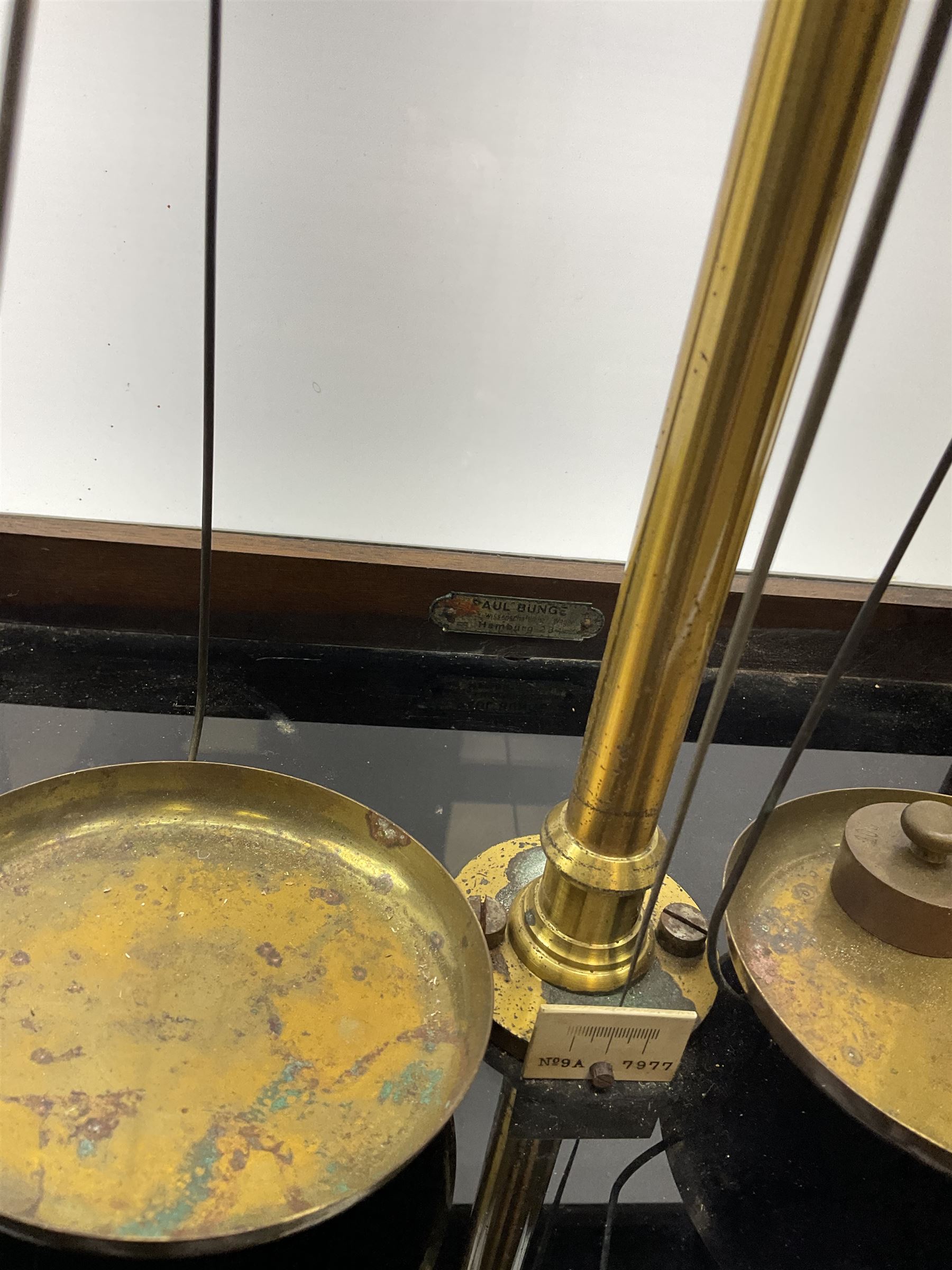 Set of laboratory balance scales by Paul Bunge Hamburg Model 9A No.7977 bearing label for Reynolds & Branson Leeds in mahogany case with upward sliding front door, two hinged side doors, hand cranked rise-and-fall facility and black vitrolite base L36cm H42cm D26cm; and two boxed part sets of weights (3)