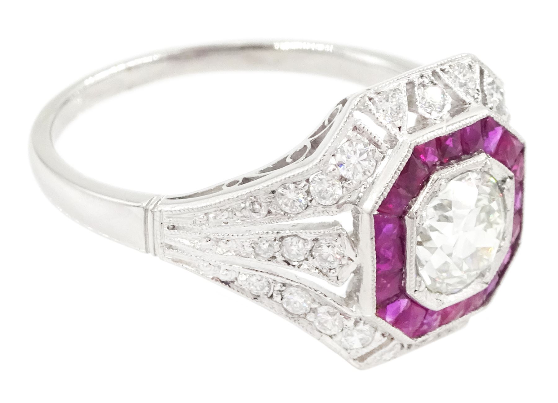 Platinum diamond and ruby cluster ring, the principal transitional cut diamond of approx 0.65 carat, in an octagonal milgrain setting, surrounded by calibre cut rubies, to further round brilliant cut diamonds and a split design shoulders