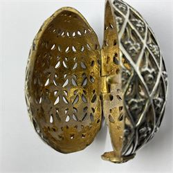 Modern silver limited edition Easter egg, no. 70/500, the openwork lattice body decorated with gilded panels of flower heads, opening to reveal a gilt interior, upon silver stand with three scrolling pad feet, each hallmarked St James House Company, London 1979, height including stand 8cm