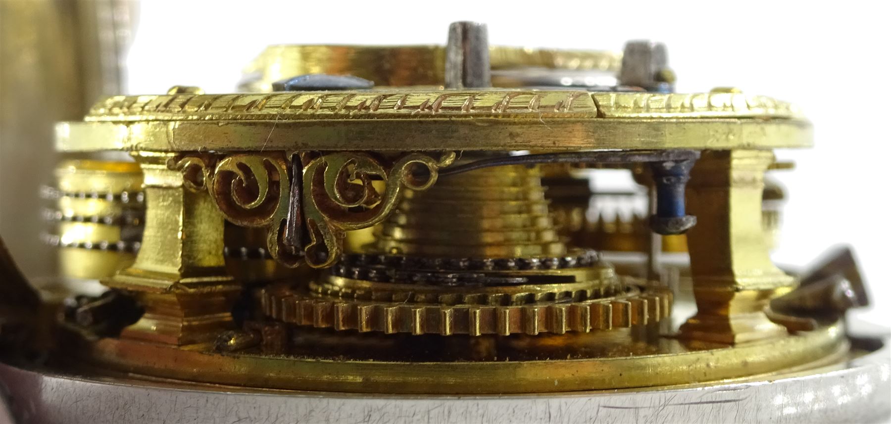 George III silver pair cased verge fusee pocket watch by David Crawford, Newcastle, No. 671, square baluster pillars, pierced and engraved balance cock, enamel polychrome dial depicting a figure fishing by a bridge, Roman hours and Arabic outer minute ring, beetle and poker hands, bull's eye glass, case markers mark D.P, London 1771