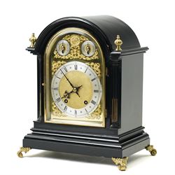 Winterhalder & Hoffmeier-8-day early 20th century mantel clock with an ebonised finish, break arch pediment and two matching brass finials, conforming glazed door with a cast brass bezel flanked by reeded quarter pilasters, on a moulded plinth with scroll feet, brass dial with cast spandrels and strike/silent and pendulum regulation dials to the arch, matted dial centre with a silvered chapter, Roman numerals  and gothic steel hands, dial pinned to a quarter striking movement sounding the quarters on two gongs and hours on one. With Pendulum.

