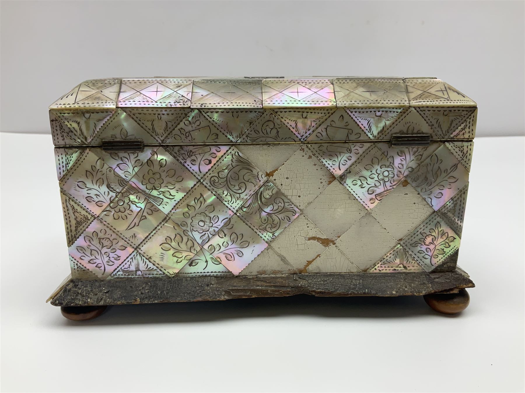 Victorian mother of pearl tea caddy, of rectangular bow-fronted form, the body with floral, bird and geometric engraved mother of pearl panels, white metal shield plaque to the cover inscribed with the initials G.J.A and similar escutcheon, the two division interior with ivory edging and two panelled mother of pearl lids, on four vegetable ivory bun feet L20cm, together with a similar style mother of pearl card case (2) This item has been registered for sale under Section 10 of the APHA Ivory Act