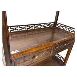 Early 20th century Chinese hardwood display étagère bookcase, the rectangular open tiered frame with pierced frieze and geometric openwork gallery to each shelf, fitted with two short drawers carved with stylised lotus motifs, supported on square uprights with pierced apron and integral gallery rails