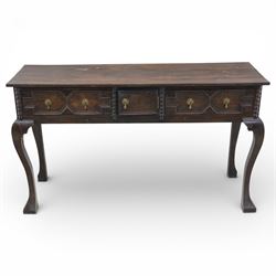 Late 19th century Jacobean revival oak side table, plank top with moulded edge over a central cupboard door and two frieze drawers carved with geometric lozenge motifs and framed by bobbin turned uprights, fitted with brass drop handles, raised on shaped cabriole supports with block feet
