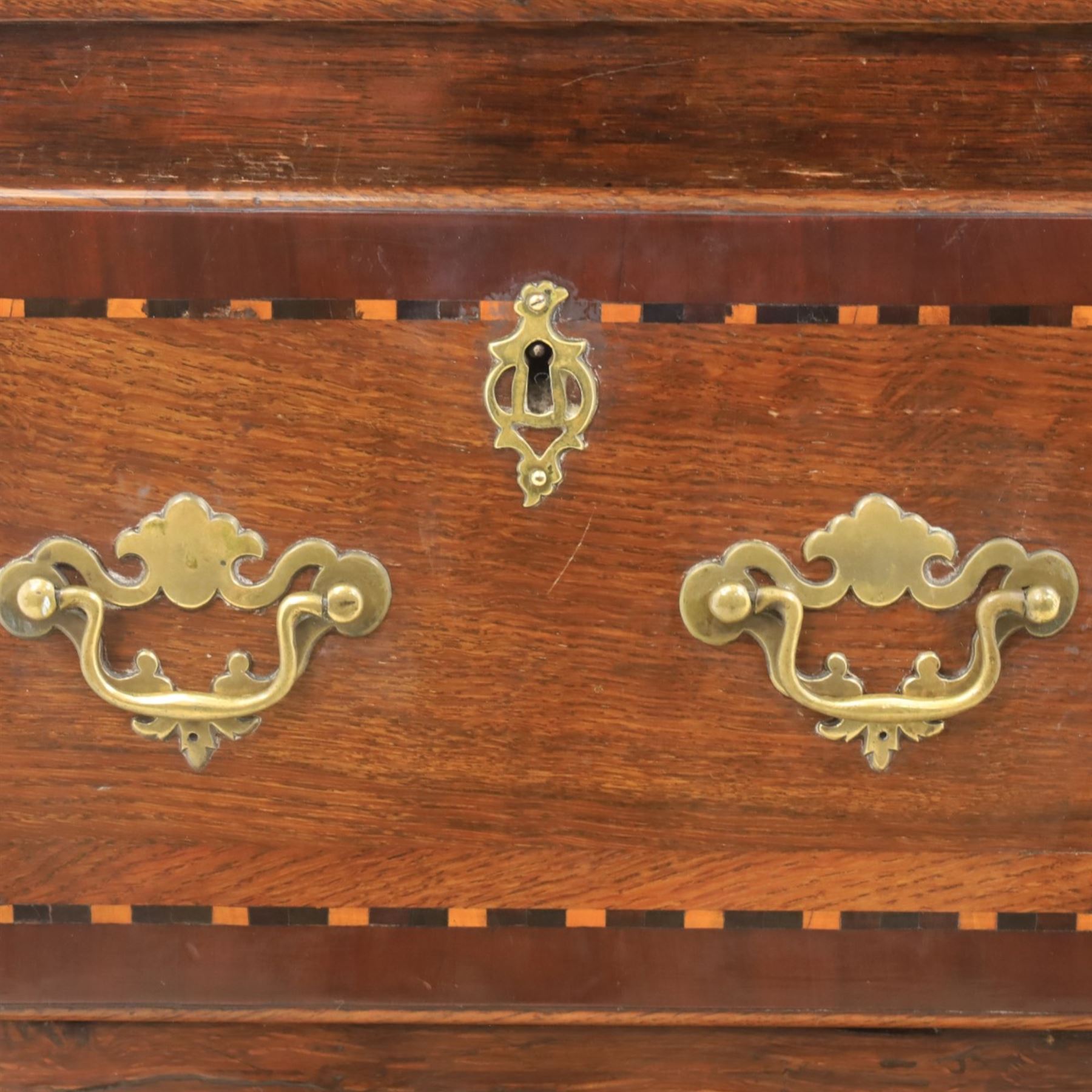 Late 19th century inlaid oak dresser and plate rack, plate rack with projecting cornice and fretwork, with three shaped shelves for plates, central cupboard with inlaid shell and border, brass escutcheon and key, the lower section with crossabanded top, above three drawers with brass handles and inlaid border, shaped apron raised on cabriole supports 
