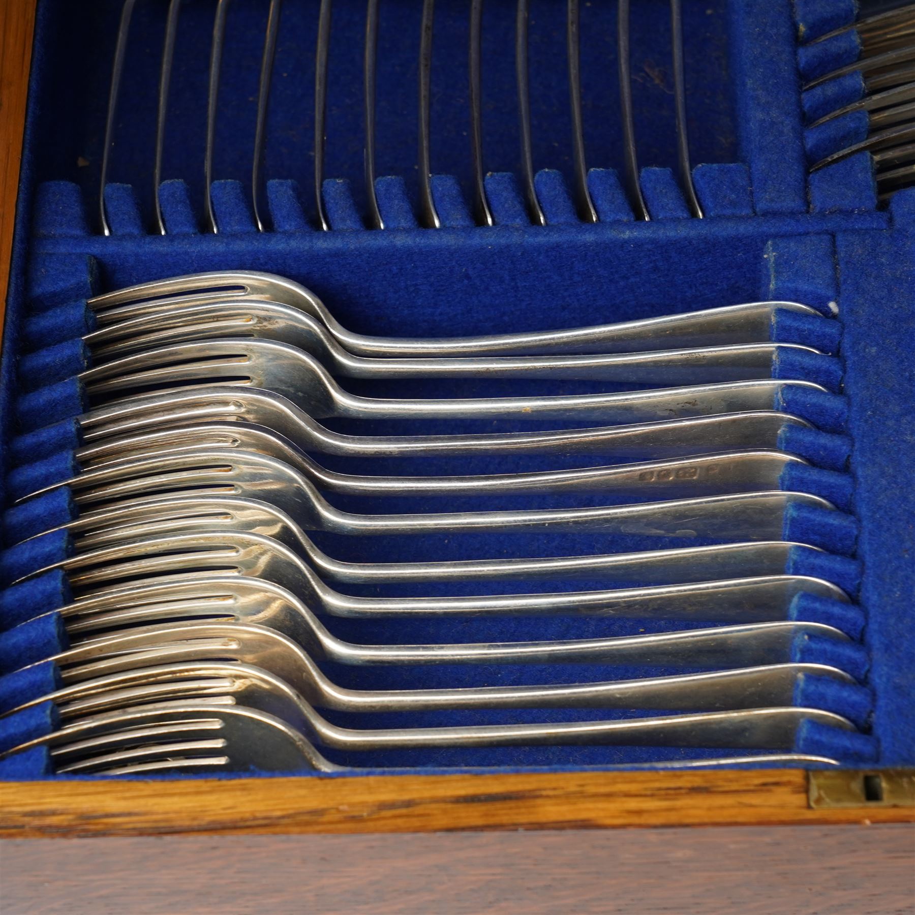  Canteen of silver cutlery comprising twelve dessert spoons, twelve dessert forks, twelve teaspoons, four table spoons and four table forks in oak case London 1938 Maker Josiah Williams & Co