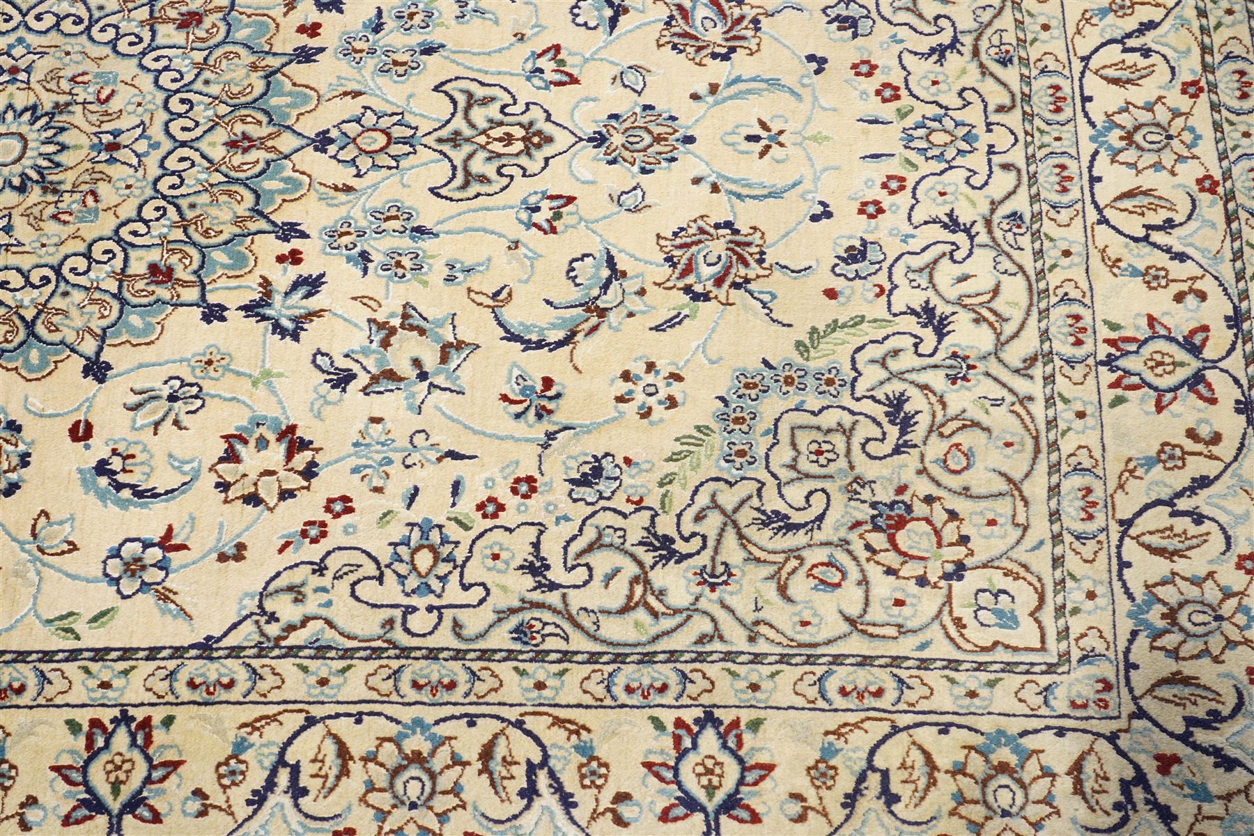 Central Persian Nain hand-knotted silk and wool rug, ivory field with a cusped medallion  issuing radiating pendants, with an all-over design of scrolling arabesques, palmettes and floral sprays, framed main border of meandering vinery and stylized palmettes, flanked by narrow guard stripes, cotton fringe ends  