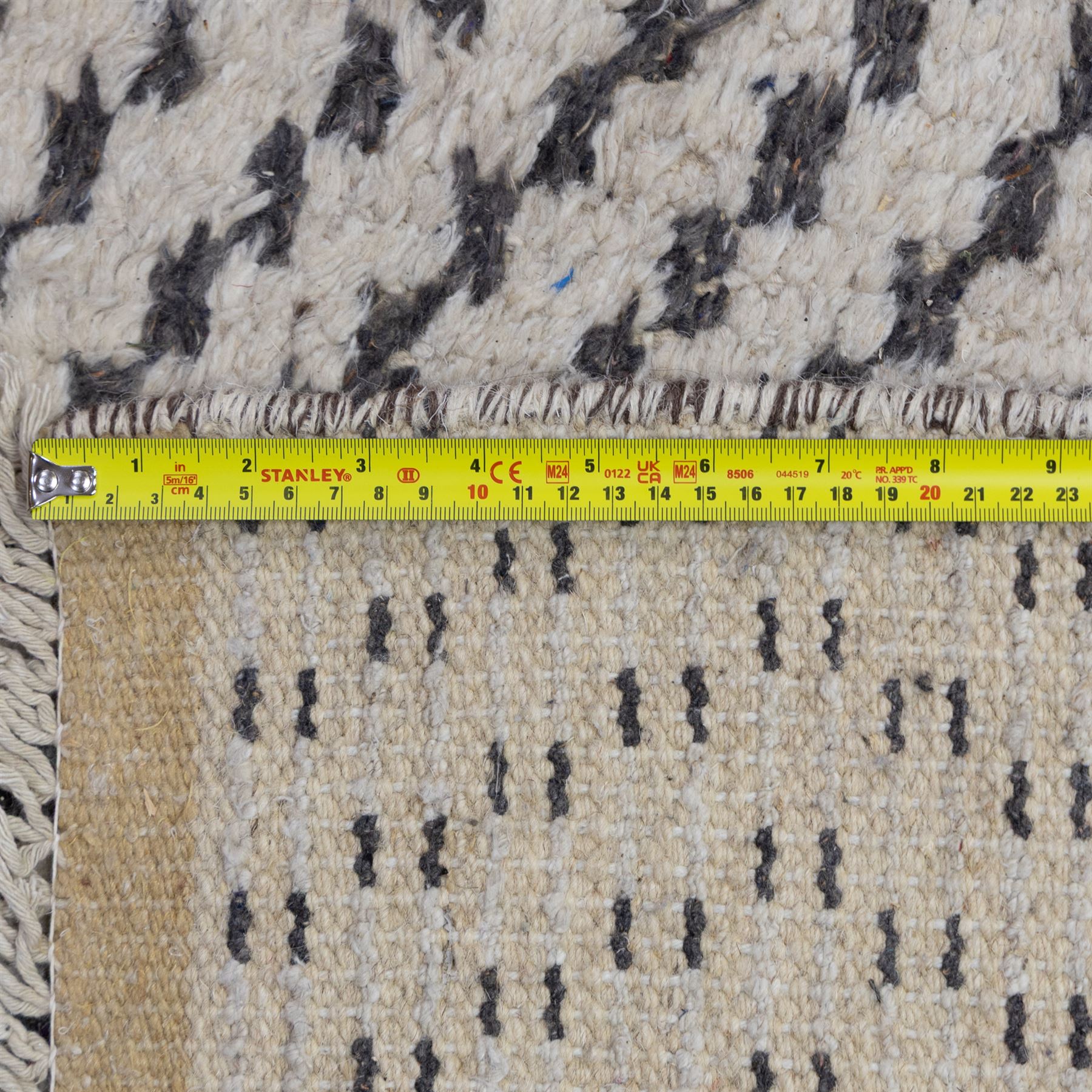 Contemporary Beni Ourain style wool rug, woven with a cream field and dark brown geometric chevron lattice, centred by repeating small diamond medallions, with short fringe ends