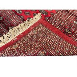Persian Bokhara crimson ground carpet, the field decorated with repeating Gul motifs and lozenges, the multi-band geometric border with stylised plant motifs, two additional bands at the ends with geometric lozenges