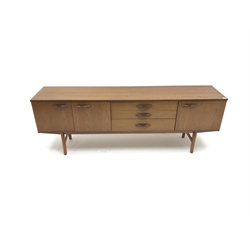  Mid 20th century Avalon teak sideboard, three graduating drawers flanked by three cupboards, tapering supports, W204cm, H72cm, D44cm  