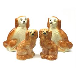 A pair of large 19th century Staffordshire dogs with glass eyes, H34cm, together with another smaller pair with glass eyes, H26.5cm, each in the form of a spaniel with russet coat. (4). 