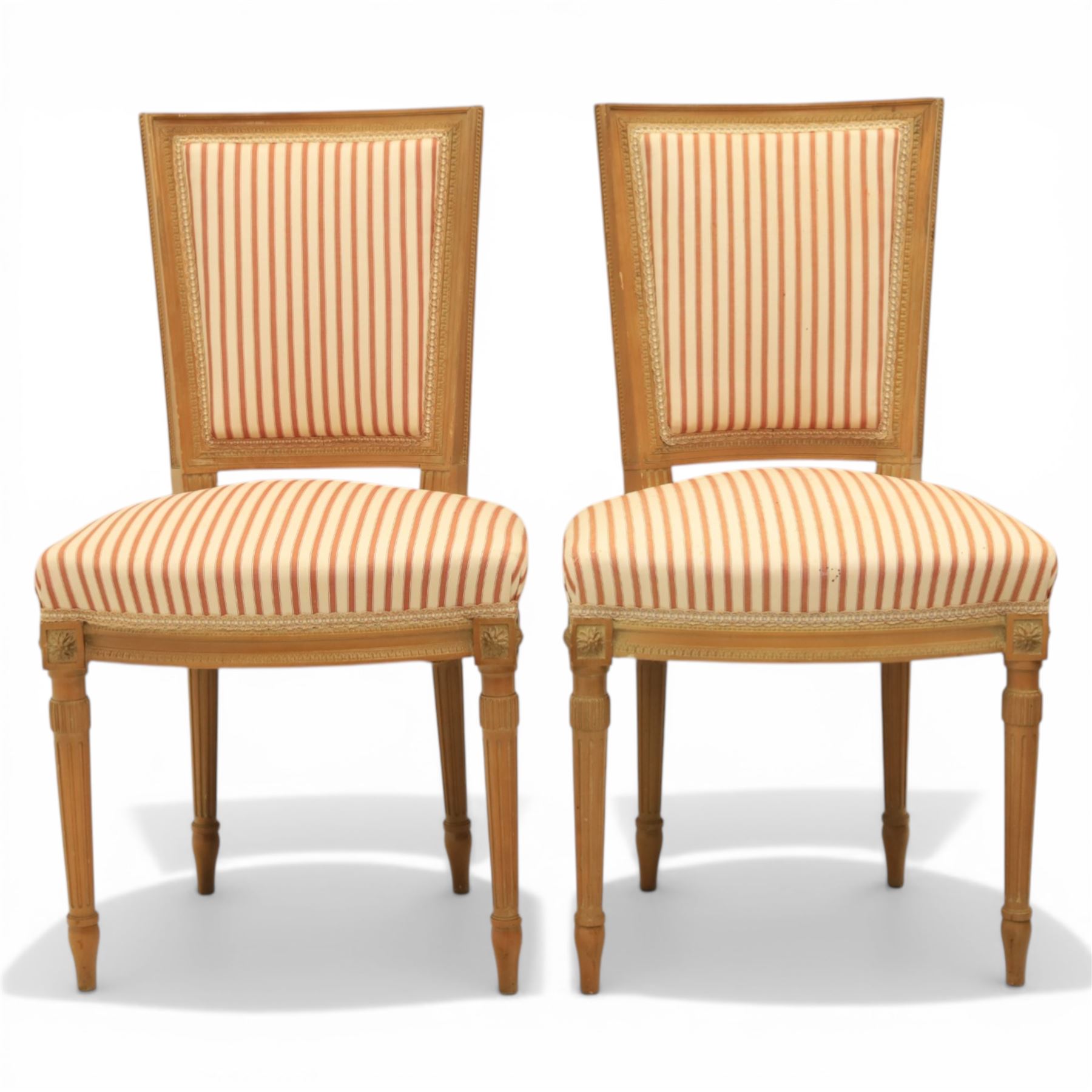 20th century Louis XVI style beech salon suite, comprising settee and four chairs, the settee with shaped rectangular back and upholstered arms over a shaped seat, the chairs with rectangular backs and overstuffed seats, each upholstered in striped fabric with close-nailed borders, upon fluted tapering supports headed by carved paterae, terminating in toupie feet, chairs H89cm W47cm