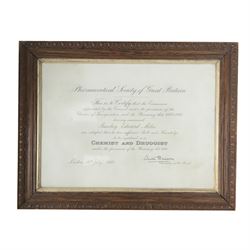 Carved birthing stool on three legs, together set of cased balance scales and framed certificate for Pharmaceutical Society of Great Britain 