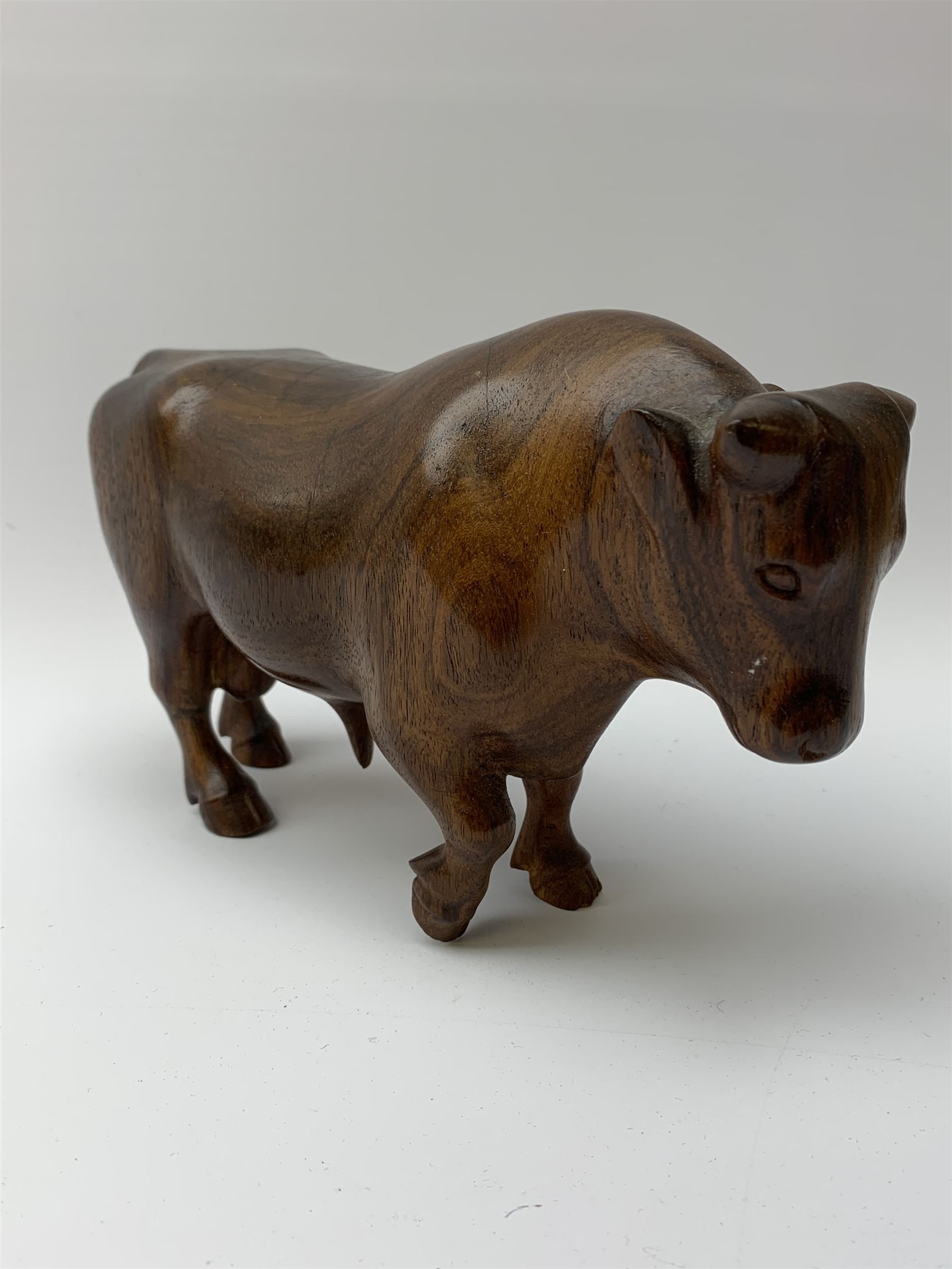 Ann Baxter (British b. 1969): a carved wooden model of a Bull, signed beneath A.W. Baxter, L22cm x H14cm 