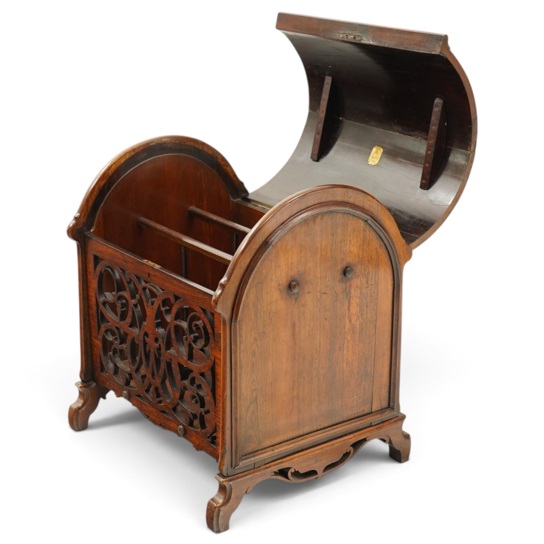 Victorian rosewood enclosed music Canterbury, the domed hinged cover enclosing a three-division interior, above a pierced scrolling foliate fretwork front panel, flanked by curved uprights and raised on scroll feet, hinged top applied with brass registration lozenge for 19 January 1860