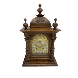A German oak cased striking mantle clock manufactured by Junghans, Schramberg, Baden-Württemberg, c1900, flat topped pediment with a carved crown and matching turned finials, glazed break arch door with carved and turned columns attached, brass dial with spandrels and a matted centre, silvered chapter, upright Arabic numerals and minute track with steel fleur di Lis hands, pinned to an eight-day striking movement sounding the hours and half hours on a coiled gong. With pendulum. 
 
	

