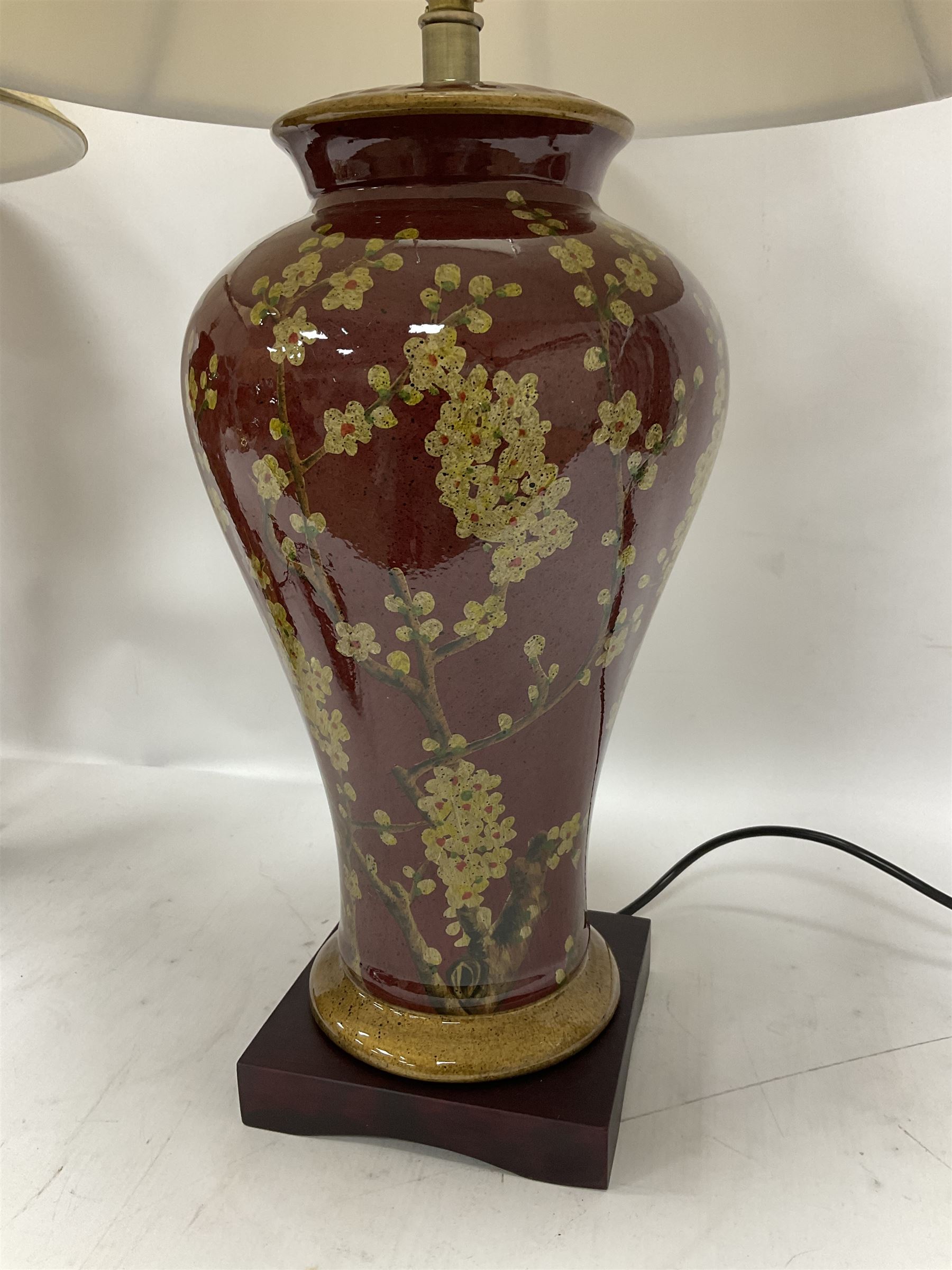 Pair of large table lamps of tapering form, decorated with Japanese blossom on a red ground, upon a square base, including shade H72cm