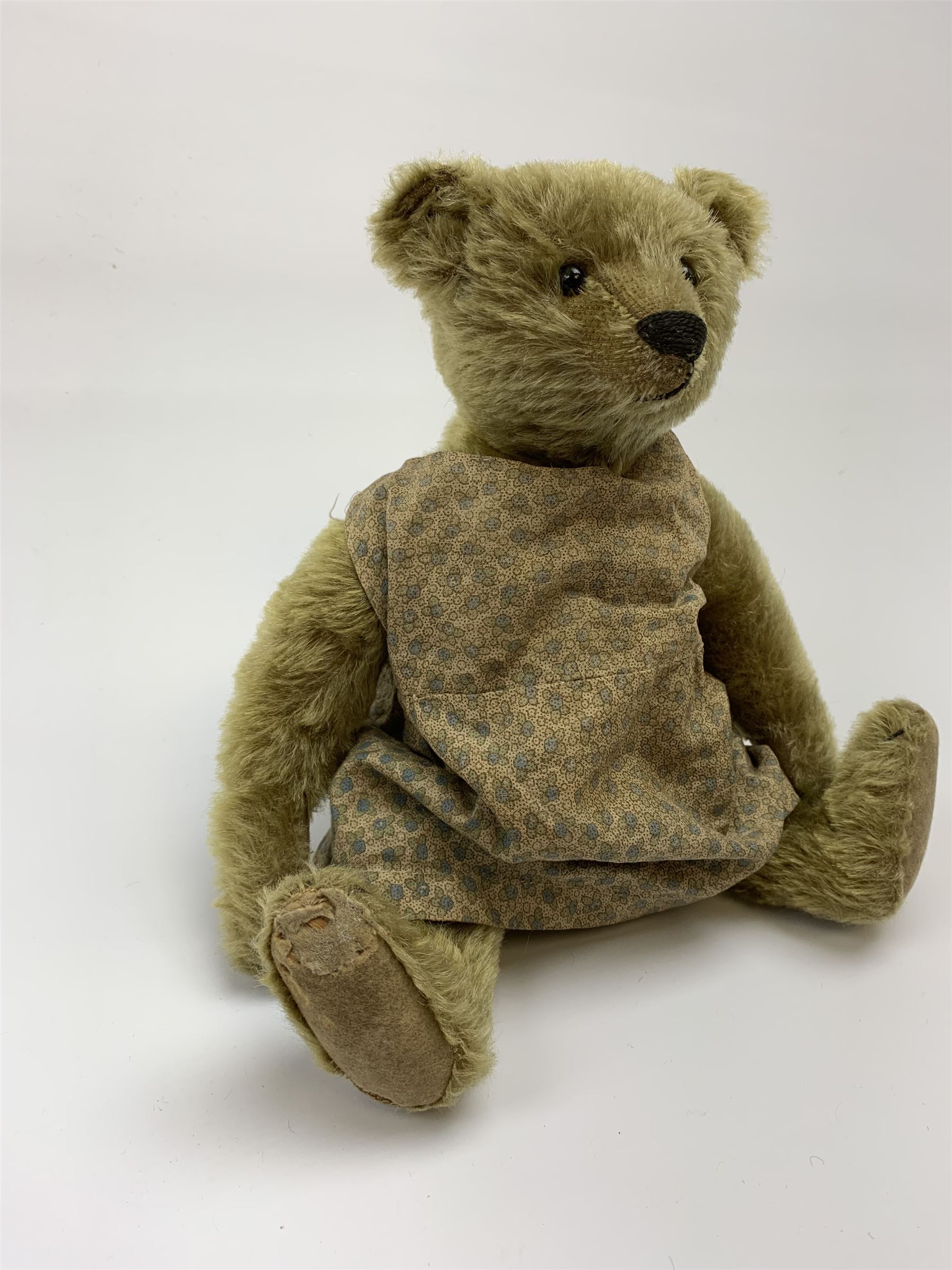 Early 20th century German Steiff teddy bear c1910 with wood wool filled humped back mohair body, swivel jointed head with black boot button eyes and horizontally stitched black nose and mouth, FF metal button to left ear, jointed elongated limbs with felt paw pads and black stitched claws H13
