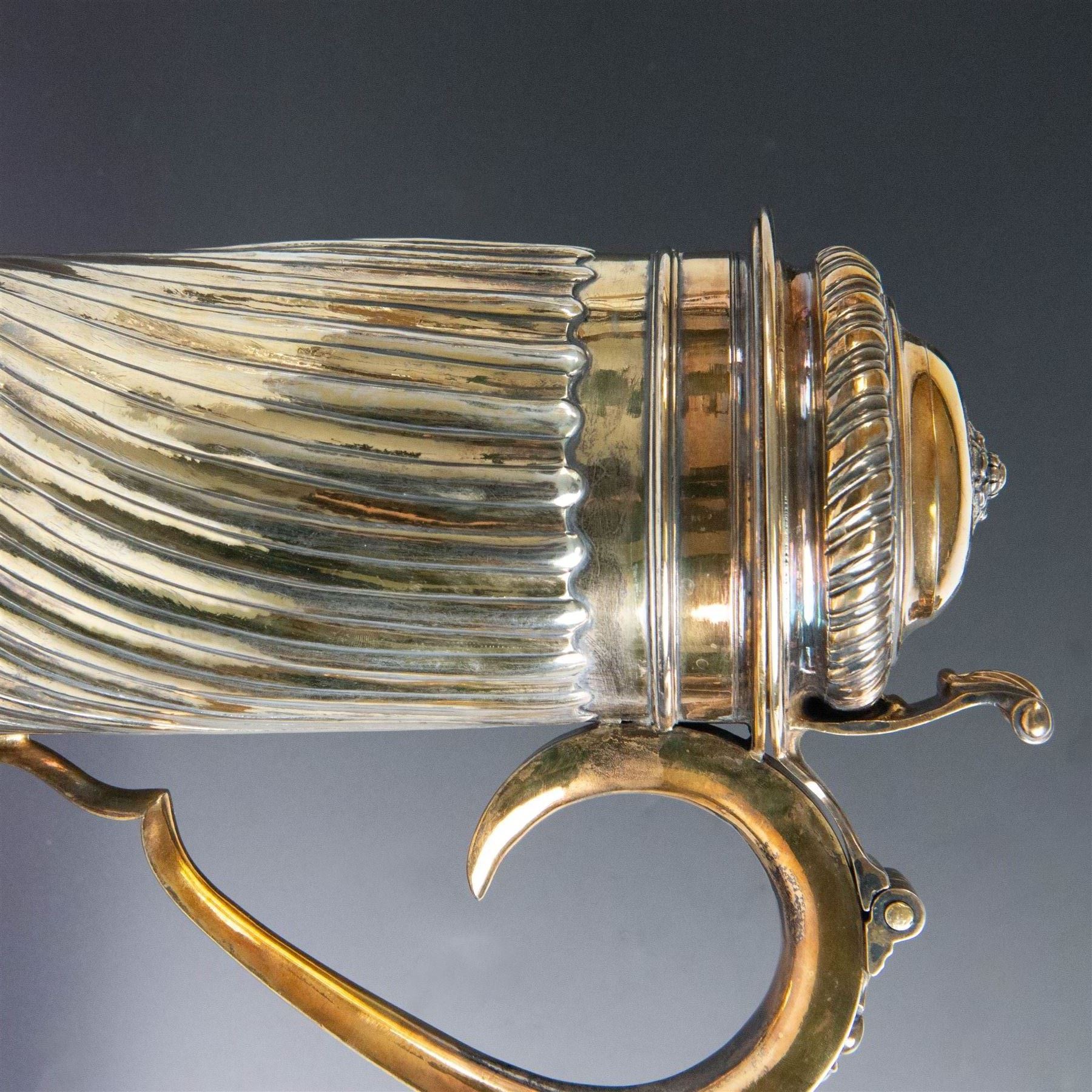 George I silver-gilt wine flagon, of tapering cylindrical form with part fluted body and upon circular spreading foot, with c-scroll handle, domed lid with rose to centre  and scroll thumb piece, hallmarked London 1725, maker's mark indistinct, with later refinements, the original hallmarks struck-through and re-assayed by the London Assay 2021, H33cm