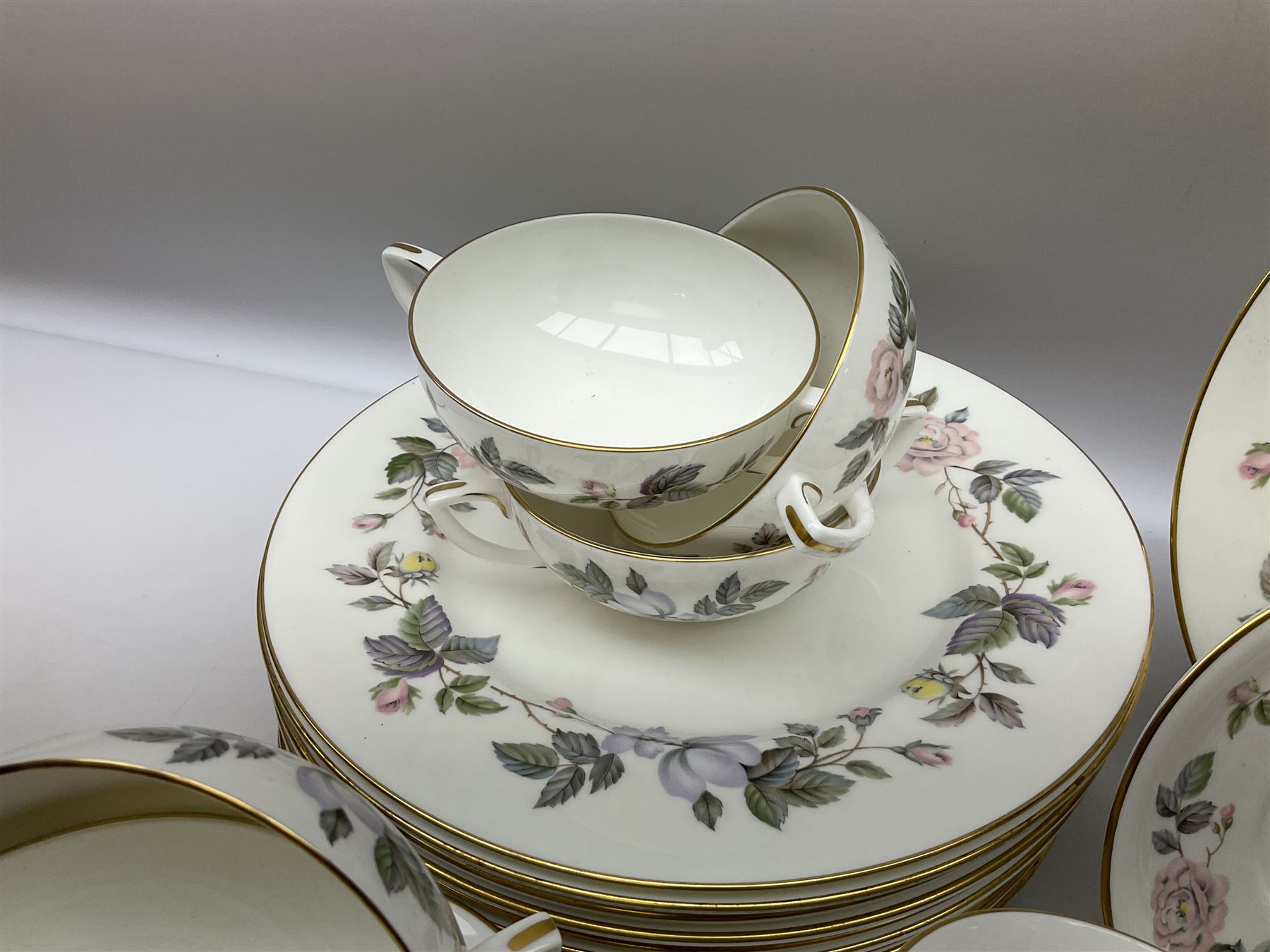 Royal Worcester June Garland pattern tea and dinner wares, comprising thirteen dinner plates, twelve dessert plates, twelve side plates, six twin handled soup bowls and six saucers, six small bowls, sauce boat and stand, thirteen teacups and fifteen saucers, open sucrier, and milk jug