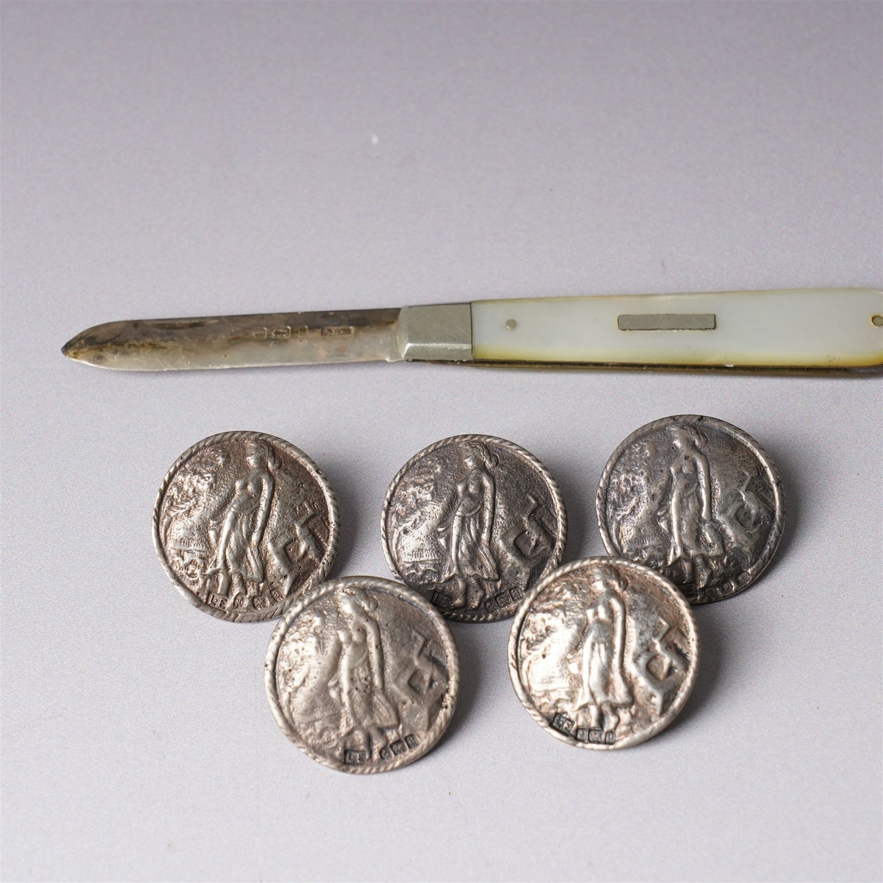 Five late Victorian silver buttons with a raised pattern of a female figure Birmingham 1900 Maker Laurence Emanuel and a silver bladed and mother of pearl fruit knife