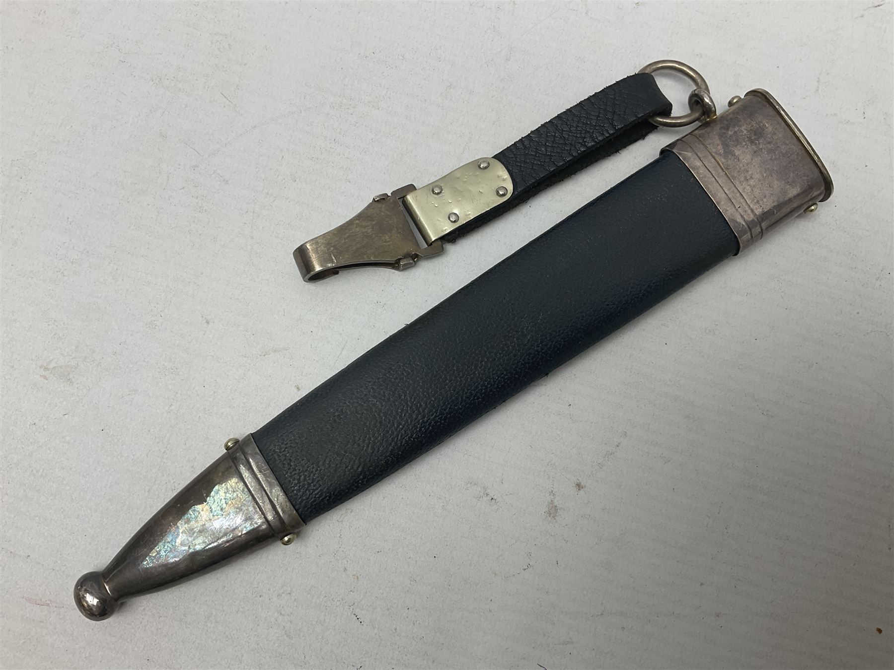 German Paul Weyersberg & Co Solingen DLV flyers dagger with 18cm steel blade, plated brass/tombac downswept cross-piece and pommel and leather covered grip, in leather and plated brass/tombac scabbard with leather hanger strap and silvered knot L35cm overall. Auctioneer's Note: After WWI Germany was forbidden an air force by the Treaty of Versailles however the Deutscher Luftsport-Verband (German Air-sport Association) was formed in March 1933 from various sports flying clubs and had branches for aeroplane, gliding and balloon flying. Under cover of the sporting DLV, many future Luftwaffe pilots trained to fly. DLV was embodied with the NSKK in March 1935 and on 1st March 1937 Luftwaffe was formed.