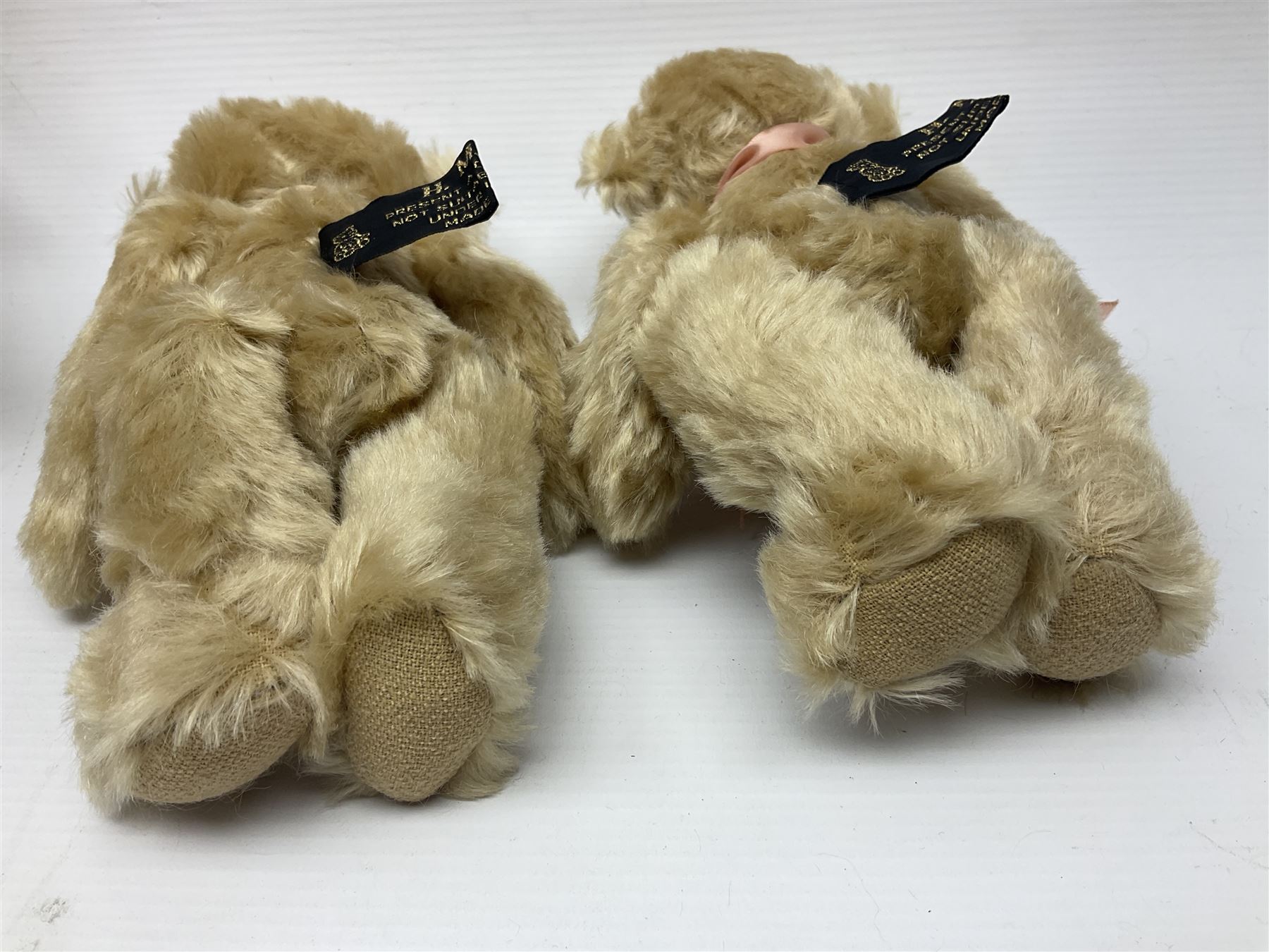 Group of five teddy bears comprising ‘George’ a unique pellet filled bear with glass eyes and velvet paws H38cm, and ‘Abbey’ a luxury German plush with wobble head and glass eyes no.5/10 H24cm, both with Teddies from Bearyland labels; along with two light blonde mohair H. M. Bears and Boyds Bears ‘T. F. Wuzzies’ no. 595140 (5)