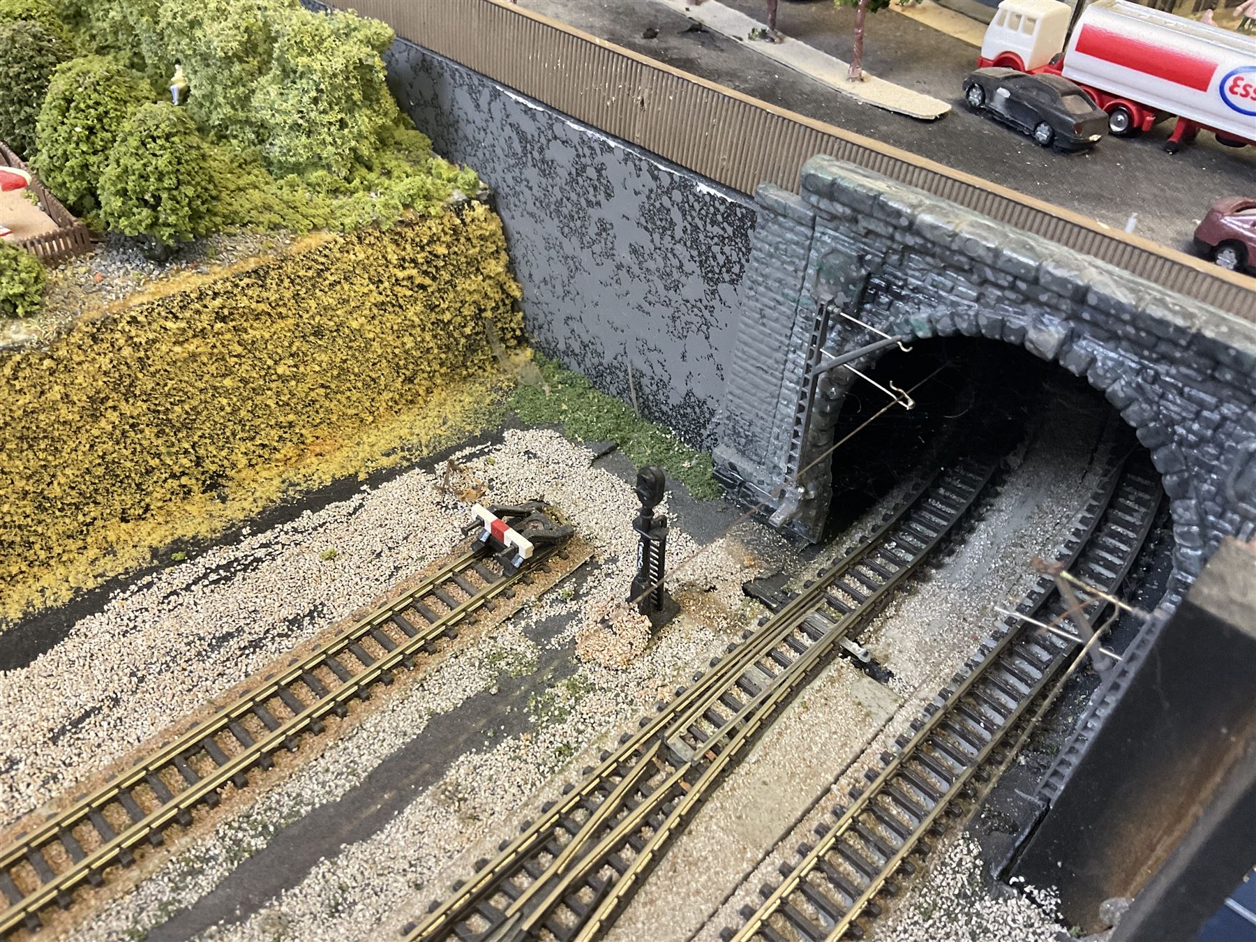 'Z' gauge continental scenic layout with folding legs, various loops of track and sidings with overhead cables, buildings including water tower, tunnels, roads with motor vehicles and figures, trees, haven with boats, backdrop diving wall hiding control units 150 x 50cm