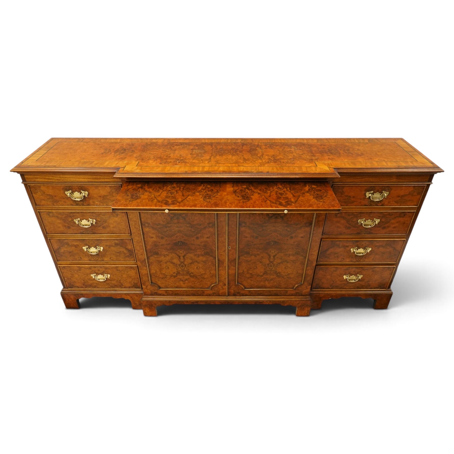 Georgian design figured and burr walnut breakfront sideboard, shaped rectangular top inlaid with crossbanding and stringing, fitted with central brushing slide over cupboard enclosing single adjustable shelf, flanked four graduating cock-beaded drawers to each side, raised on bracket feet
