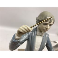 Two Lladro figures, comprising Conductor no 5196 and Prayerful Moment no 5500 together with a Lladro plaque and two Lladro candle holders, Dolphins at Play no 17666 and Sailing the Seas no 17665, all with original boxes, largest example H33cm 