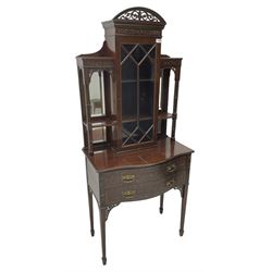 Early 20th century mahogany cabinet on stand, with pierced arched foliate pediment over blind-fretwork frieze, fitted with single astragal glazed door flanked by bevelled mirror back shelves with cluster column uprights, serpentine base fitted with two drawers with blind-fretwork facias 