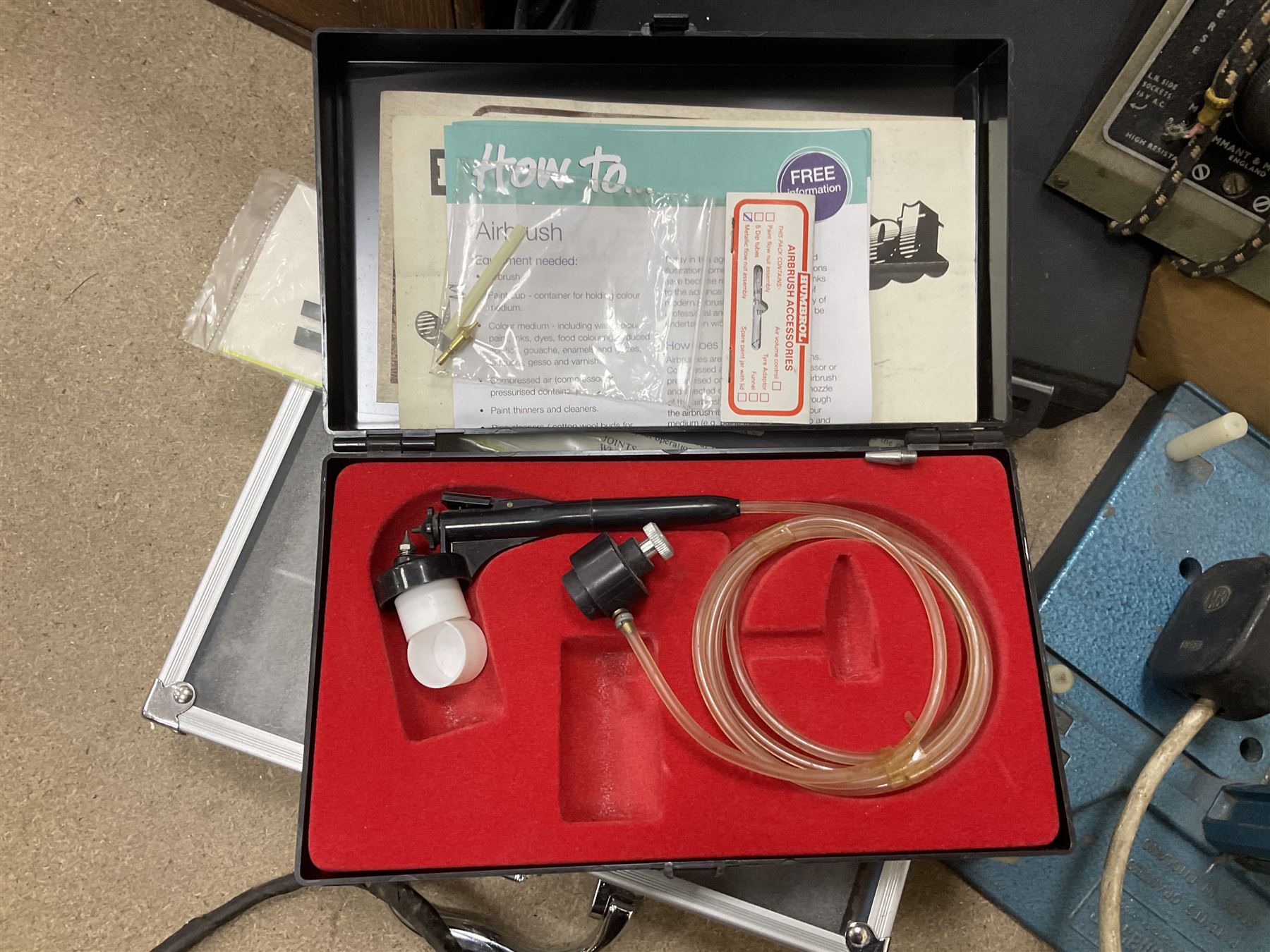 Six shelved cabinets for displaying ‘00’ gauge locomotives comprising plain plywood and white painted examples with track applied to various shelves, largest H63cm, W107cm, D27cm; Collection of tools for building model locomotives to include Weller PU-2D Soldering Pencil and Standard Tip Soldering Iron 20W/230V, Humbrol Modellers Airbrush, Power Supply Units and two wooden chests one of which housing a collection of tools including tweezers, scalping tools, wrenches etc 