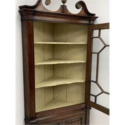 George III oak floor standing corner cabinet, scrolled swan neck pediment with central finial over astragal glazed door, painted interior fitted with three shaped shelves, the lower section fitted with single shaped shelf enclosed by two fielded panel doors inlaid lozenges, on bracket feet, H195cm, W77cm