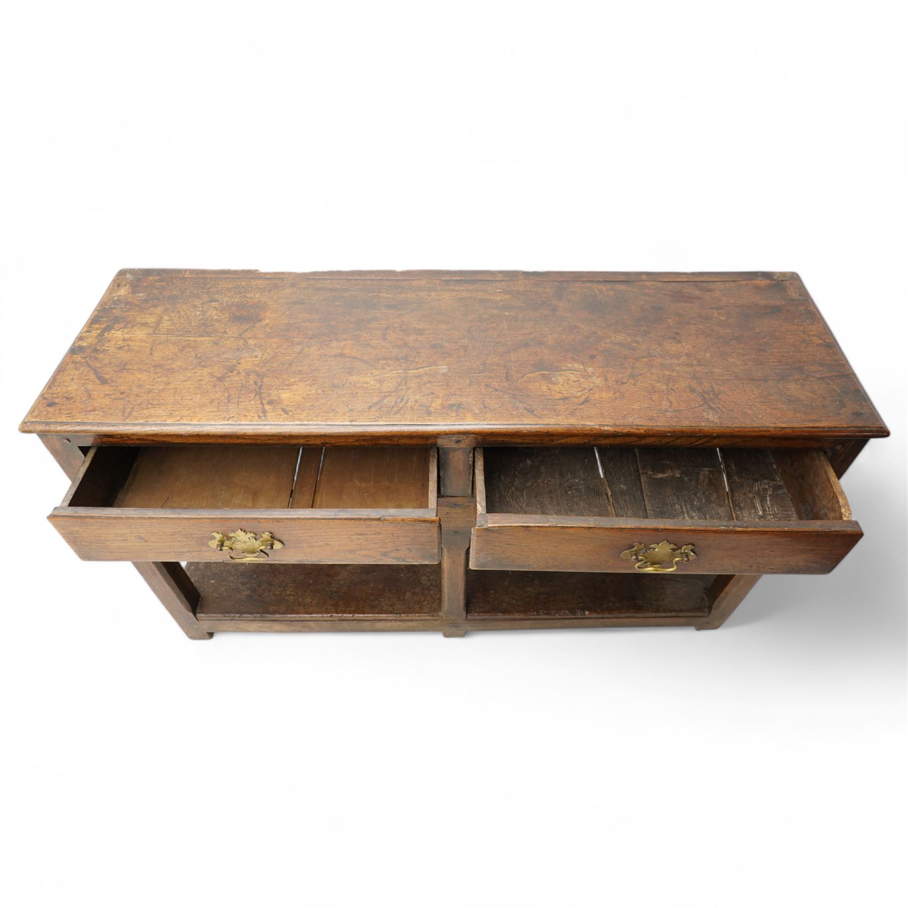 18th century oak dresser base, moulded rectangular top over two drawers and shaped apron, moulded drawer fronts fitted with shaped brass handle plates and swan neck handles, on chamfered square supports united by pot board base 