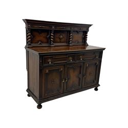 Jacobean-style oak dresser base with two frieze drawers above three cupboards with panelled and moulded decoration, fitted with drop handles, supported on bun feet, circa 1900