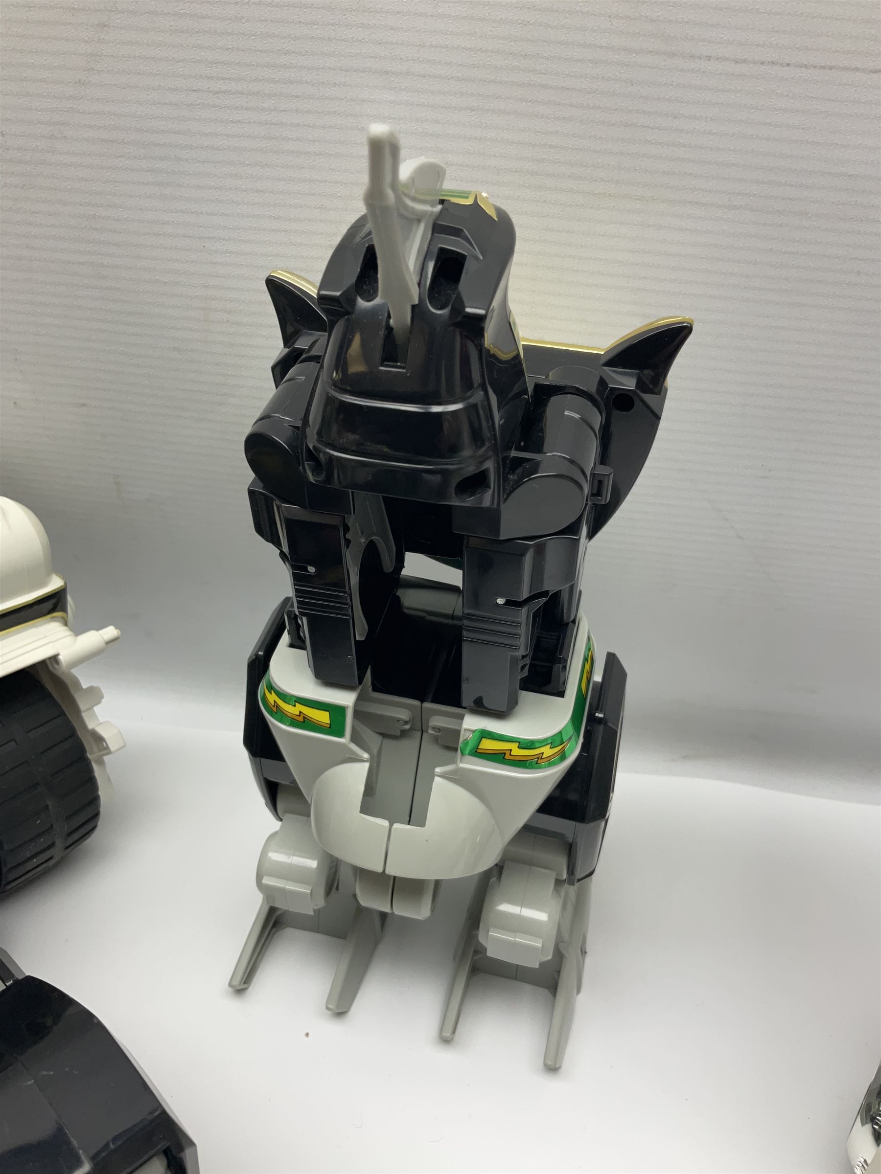 Collection of early 90s Mighty Morphin’ Power Rangers Zords, figures and accessories. Titanus the Carrier Zord, marked Bandai 1991; Green Dragonzord, incomplete; 1994 White Tigerzord with original instruction manual; 1993 Triceratops Dinozord, Mastodon Dinozord and Sabertooth Tiger Dinozord, Pterodactyl Dinozord, missing guns; with 1993 Power Morpher and original Power Coins, with further related figures, accessories and weapons