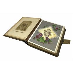 Victorian leather bound musical photo album, the interior leaves containing apertures of various sizes and shapes of portraits surrounded by printed floral designs with lace and cushion detail, with boxed key wound music combination, brass clasp and painted gold decoration to cover and edges