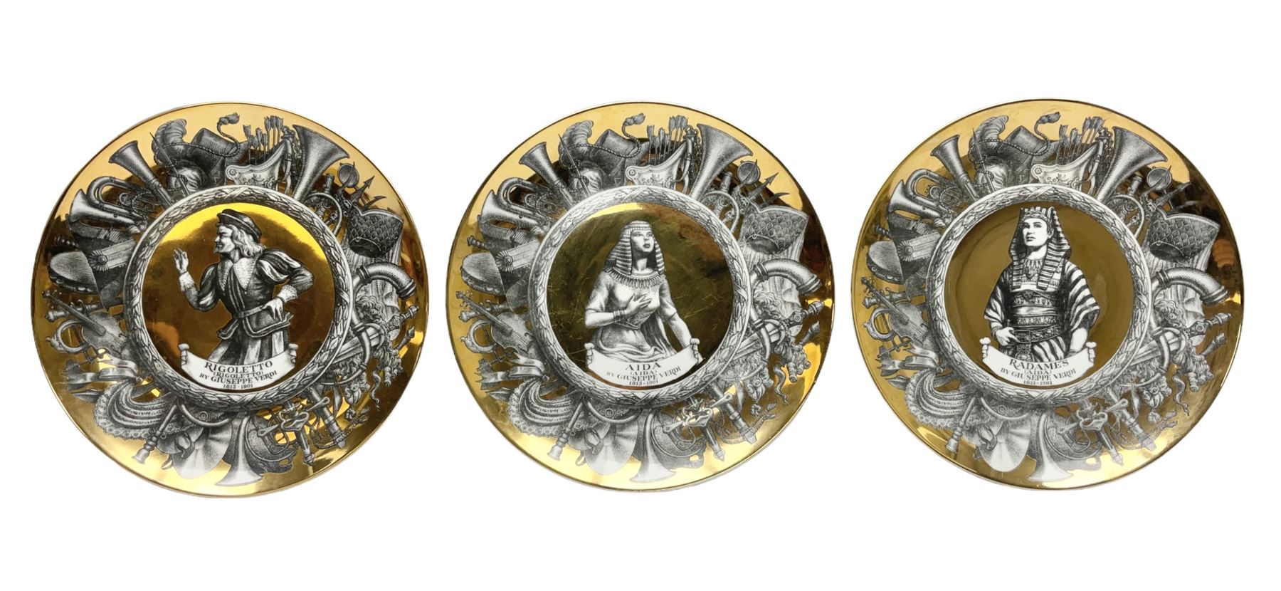 Three Fornasetti plates from the Melodramma series, each depicting a operatic portraits within a border of operatic emblems on gilt ground, with printed mark beneath, D25cm 