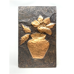 A hammered copper wall plaque, of rectangular form depicting in relief a flower contained within a vase, H82cm L51cm. 