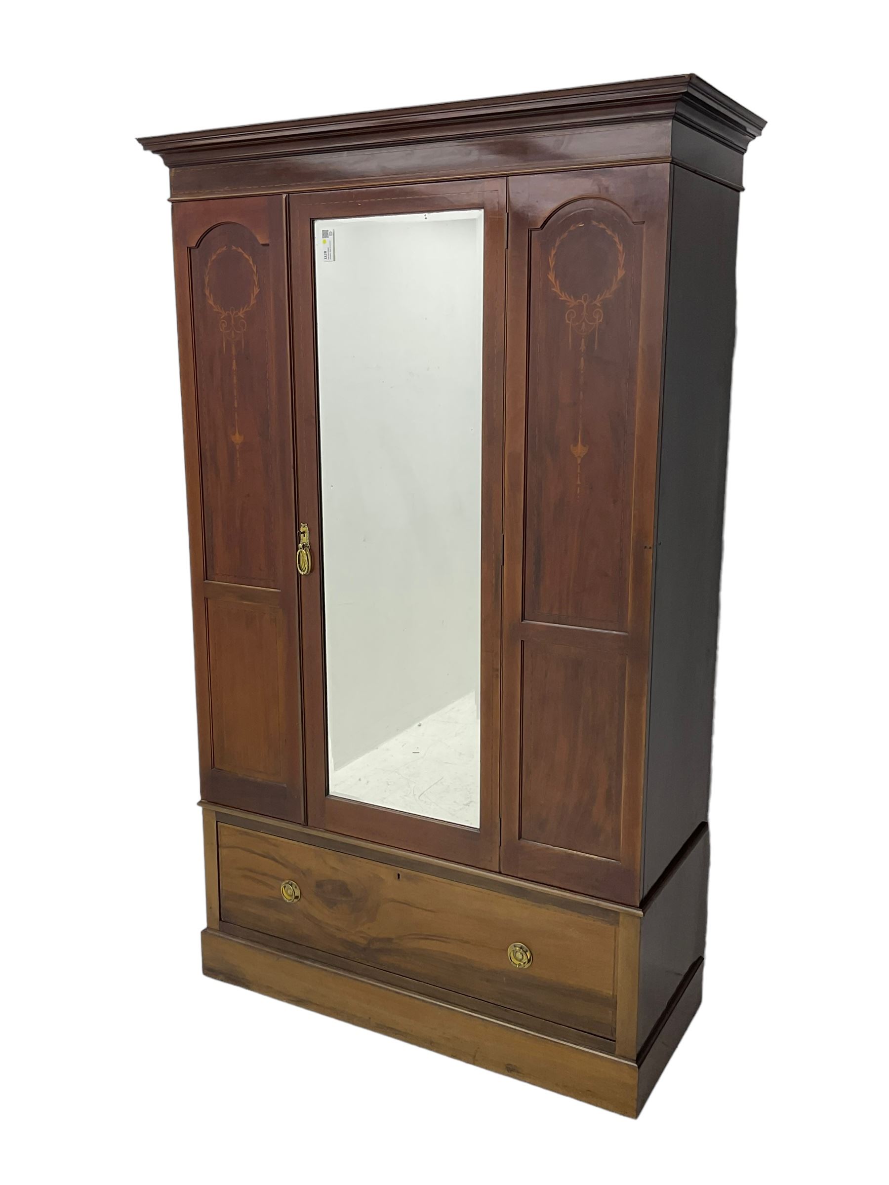 Edwardian inlaid mahogany wardrobe, projecting moulded cornice over central bevelled mirror glazed door, panelled uprights inlaid with trailing bellflowers and foliate decoration, the skirted base fitted with single drawer 