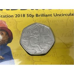 Twelve The Royal Mint United Kingdom brilliant uncirculated fifty pence coins, including 2018 '40 Years of The Snowman', 2018 'Paddington at the Station', 2020 'Peter Rabbit', etc., all housed in card folders