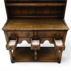 Georgian design oak dresser of small proportions, moulded cornice over open plate rack with two shelves and shaped apron, the base fitted with two drawers over three small drawers, brass drop handles, shaped apron, on square supports united by pot board